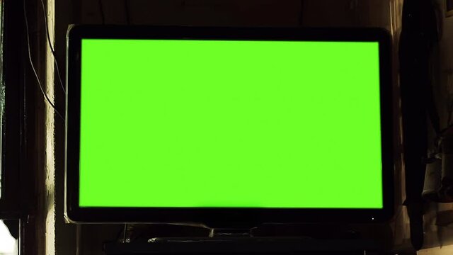 TV Set with Green Screen Mounted on Wall in a Cafe in Buenos Aires. Close Up. Zoom In. You can replace green screen with the footage or picture you want with “Keying” effect in After FXs. 4K.