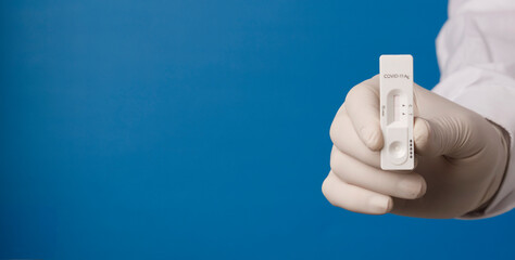 doctor hand with rapid test for coronavirus, blue background