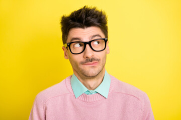 Obraz premium Photo of young attractive serious thoughtful minded man in glasses look copyspace thinking isolated on yellow color background