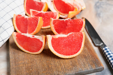 Board with slices of ripe grapefruit on table, closeup