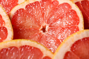 Slices of ripe grapefruits as background, closeup