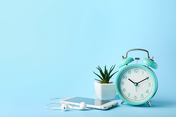 Composition with alarm clock and mobile phone on color background