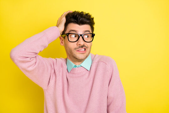 Photo of young unhappy upset worried oops guilty man in glasses look copyspace hold hand head isolated on yellow color background