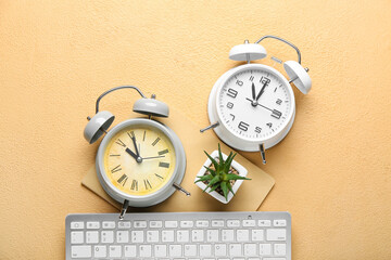 Composition with alarm clocks, computer keyboard and houseplant on color background