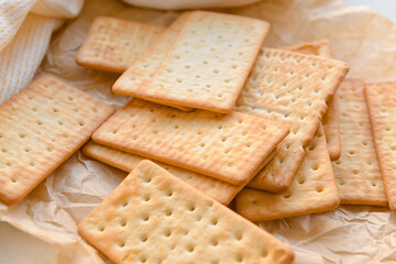 Tasty crackers on parchment paper, closeup