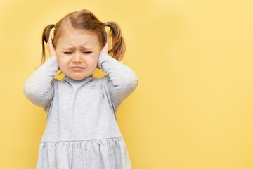 Unhappy little girl kid close eyes and ears being annoyed with noise wanting silence and calm...