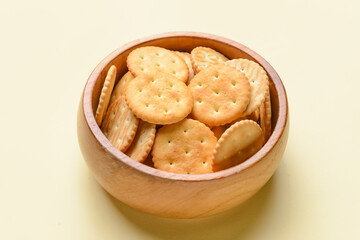 Bowl of crackers on color background