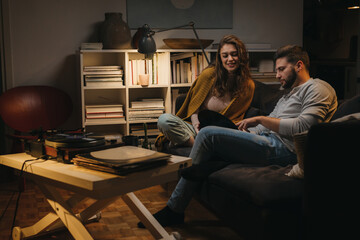 Obraz premium romantic young couple listening to a music on record player at home