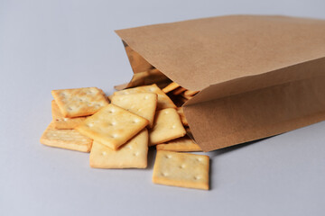 Paper bag of crackers on grey background