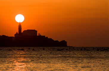 Sun on a top of curch, orange sky.