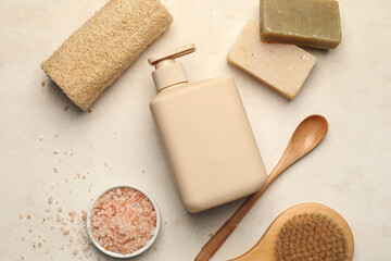 Bottle of shower gel and bath supplies on light background