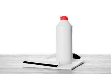 Set of cleaning supplies on wooden table against white background