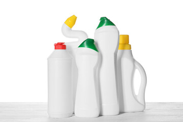 Set of cleaning supplies on wooden table against white background