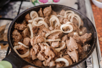 Fried veal liver with onions in a pan. Braised cow and pork liver