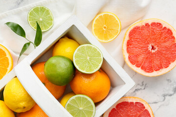 Naklejka na ściany i meble Basket with fresh citrus fruits on light background