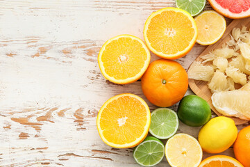 Fresh citrus fruits on light wooden background