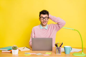 Photo of young man clueless confused no answer study online laptop isolated over yellow color...