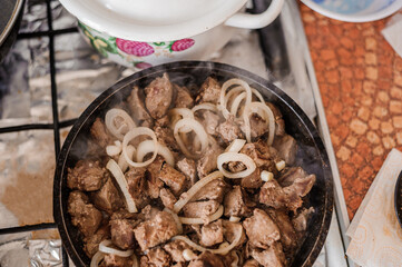 Fried veal liver with onions in a pan. Braised cow and pork liver