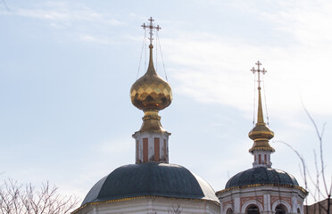 Fototapeta na wymiar Golden domes of a church temple against a blue sky