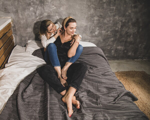 Two beautiful women enjoy communication in each other's arms while lying on the bed. Gay, lesbians