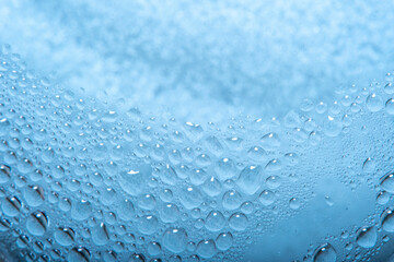 Obraz premium Blue background with water drops on glass