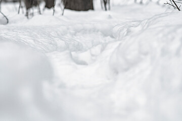 A narrow path trodden in deep snow. Background with footprints of a man in the snow.