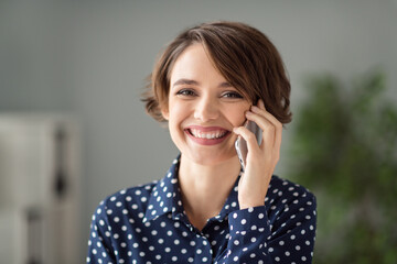 Close-up portrait of attractive cheerful brown-haired girl calling client discussing project at...