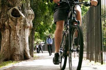 Pessoa andando de bicicleta e scooter elétrico na ciclovia em Curitiba. - obrazy, fototapety, plakaty