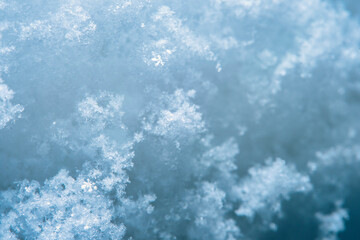 Background with close-up of snow under strong magnification. Slightly melted snow with sharp edges in soft focus.