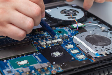 Naklejka premium Applying a new thermal paste to the laptop cooling system from a tube