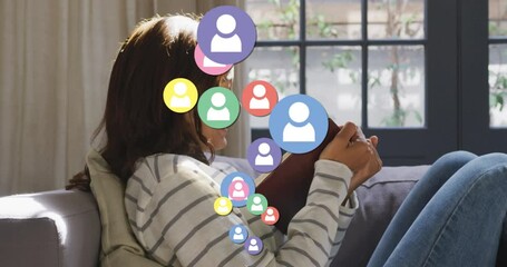 Animation of digital people icons over woman reading book and smiling at home - Powered by Adobe