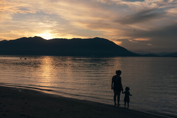 silhouette of a mother and son
 on the beach