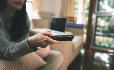 Female stay at home hand holding remote tv.