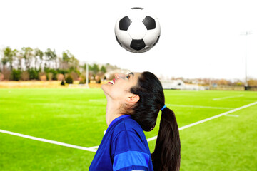 A young soccer champion trains by dribbling on the pitch. Subject on a blurred background. Perfect shot for emancipation and women's sports.