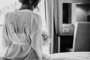 bride in white robe getting ready for wedding day 