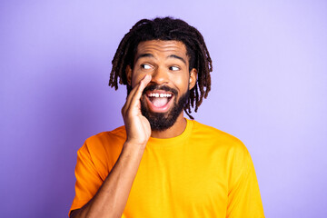 Portrait of nice optimistic brunet guy hand mouth wear orange t-shirt isolated on vibrant lilac...