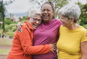 Fotobehang Happy multiracial senior women having fun together at park - Elderly generation people hugging each other outdoor © Sabrina