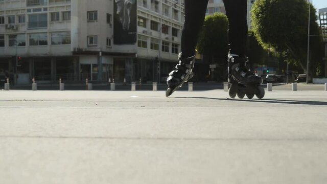 Skating on a downtown sidewalk. Creative low angle perspective as a rollerblader skates towards and over the camera.