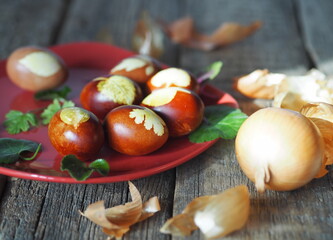 Red plate with Easter eggs with onion peel on an ancient wooden background.Easter background.