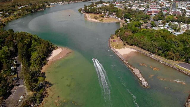 Aerial drone view following a boat on a Evans river, in New South Wales, Australia