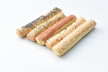 Puff pastry cheese stick, decorated with Parmesan cheese on white wooden background