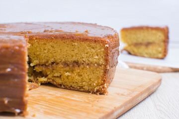 Large vanilla cake, decorated with arequipe on wooden background