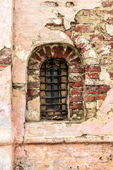 An arched window in the wall of an old church.