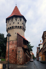 Fototapeta na wymiar Watchtower and street at Sibiu, Romania at central perspective image, after rain.
