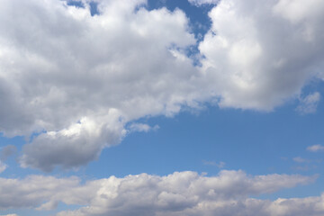 Blue sky with white fluffy clouds. Natural background with copy space. 