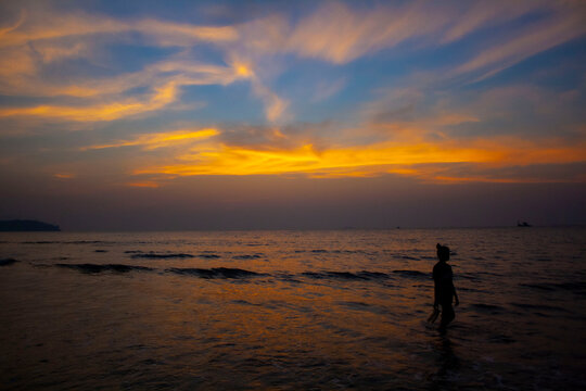A silhouette with an Indian sunset over the water © Leif