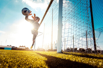 Soccer player in action on the soccer stadium - Goalkeeper catches the ball - Football and sport...
