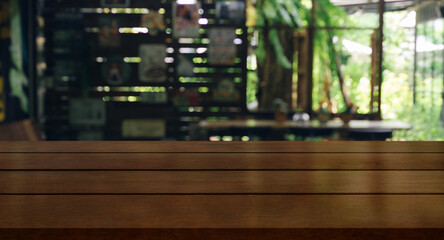Empty wooden table top with lights bokeh on blur restaurant background.