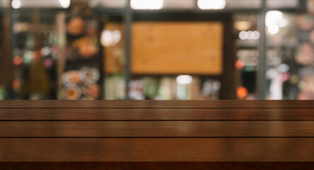 Empty wooden table top with lights bokeh on blur restaurant background.