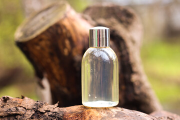 Clear bottle container with copy space for your brand. Horizontal image featuring natural wood material on nature background